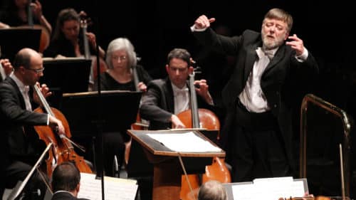 Photo of conductor Sir Andrew Davis conducting an orchestra
